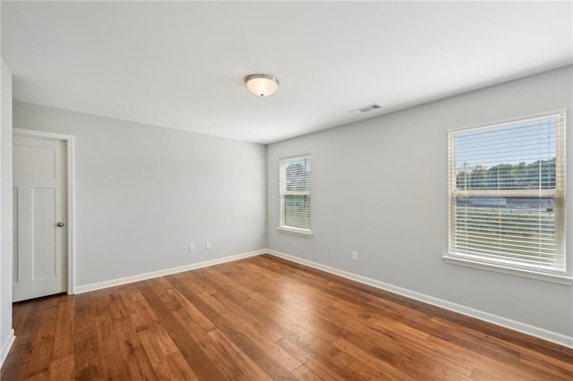 unfurnished room featuring wood-type flooring and plenty of natural light