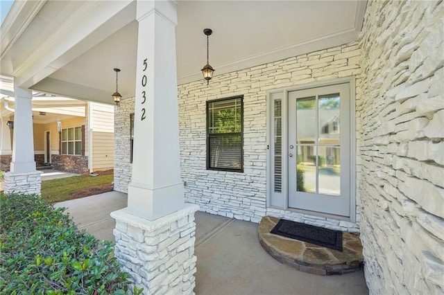 view of exterior entry featuring covered porch