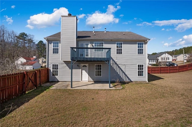 back of property with a yard, a patio, a chimney, a deck, and a fenced backyard