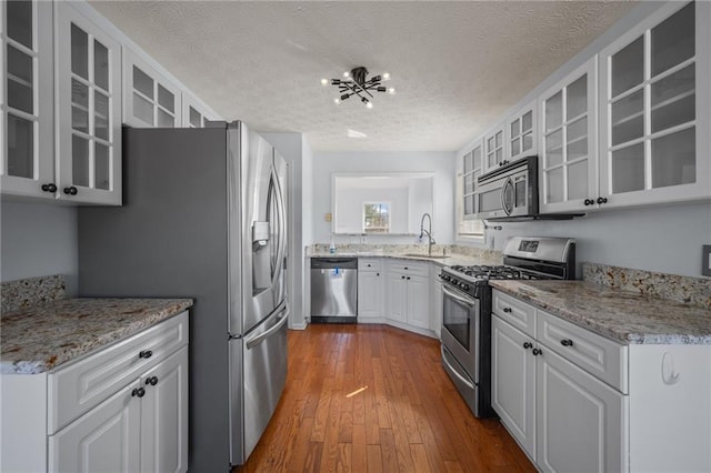 kitchen with stainless steel appliances, white cabinets, and glass insert cabinets