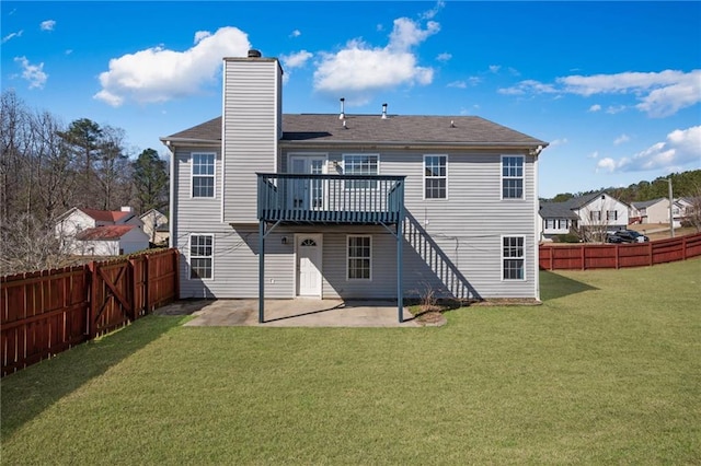 rear view of property featuring a fenced backyard, a lawn, a wooden deck, a chimney, and a patio area