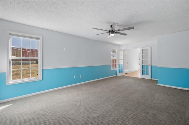 carpeted empty room featuring a textured ceiling, ceiling fan, french doors, and baseboards