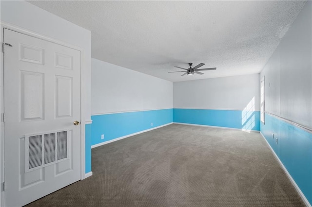 empty room with visible vents, dark carpet, a ceiling fan, a textured ceiling, and baseboards