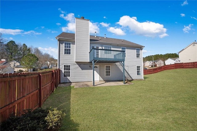 back of property with a patio area, a fenced backyard, a yard, and a chimney