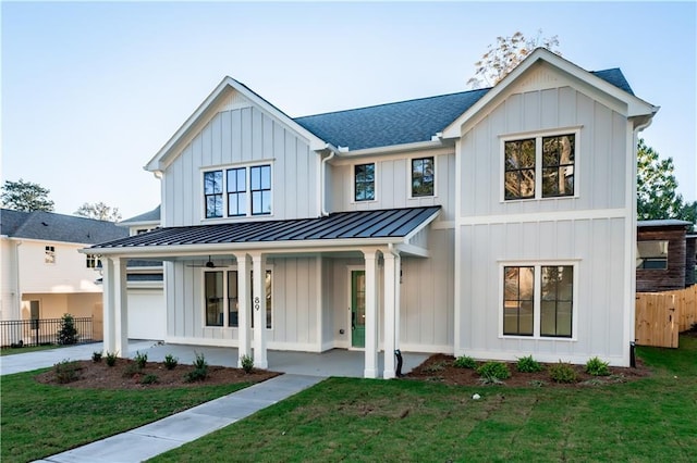 modern farmhouse featuring a front yard and a porch