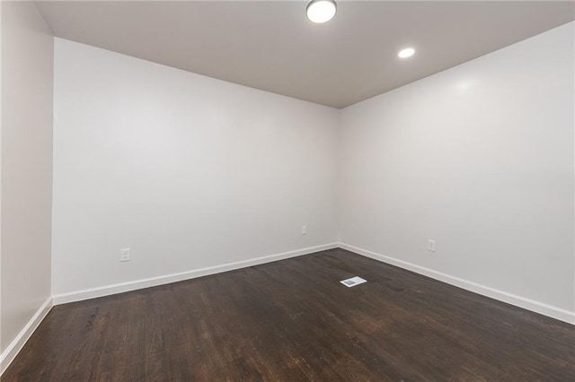 spare room featuring baseboards, recessed lighting, and dark wood-style floors