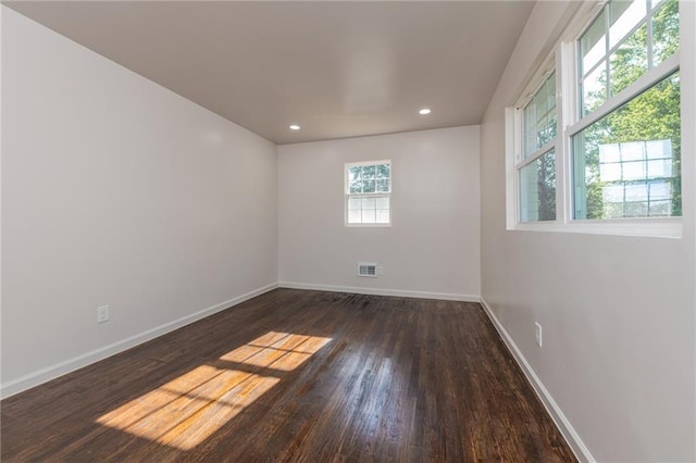 empty room with visible vents, baseboards, recessed lighting, and wood finished floors