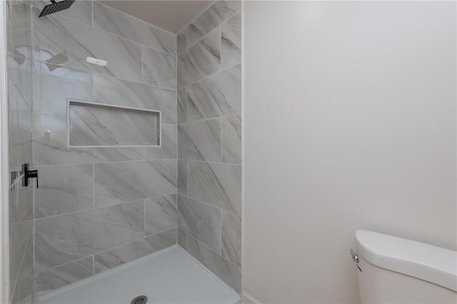 bathroom with a shower stall and toilet