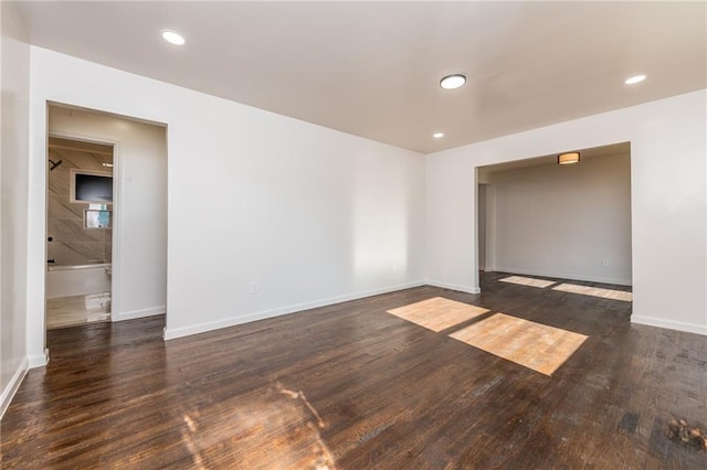 empty room with wood finished floors, baseboards, and recessed lighting