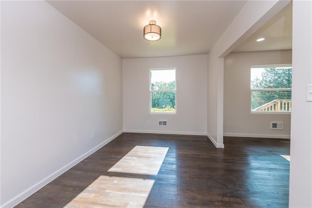 unfurnished room featuring visible vents, baseboards, and wood finished floors
