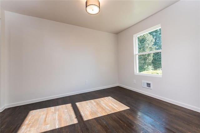 unfurnished room featuring wood finished floors, baseboards, and visible vents