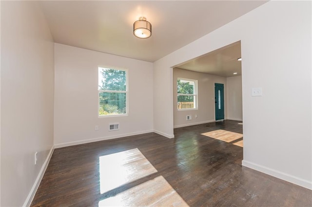 empty room with visible vents, baseboards, and wood finished floors