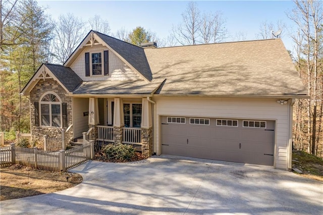 view of front of property with a garage, a shingled roof, fence, concrete driveway, and stone siding