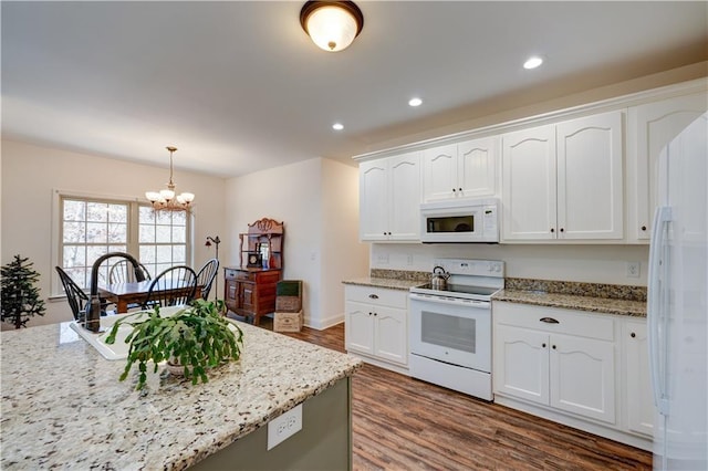 kitchen with dark wood-type flooring, white appliances, white cabinetry, and a notable chandelier