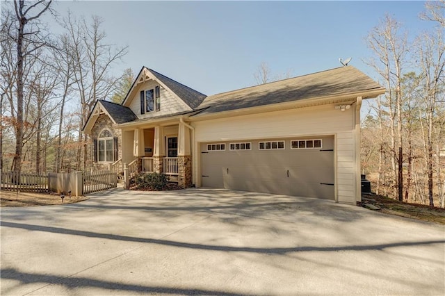 view of front of property with concrete driveway, an attached garage, and fence