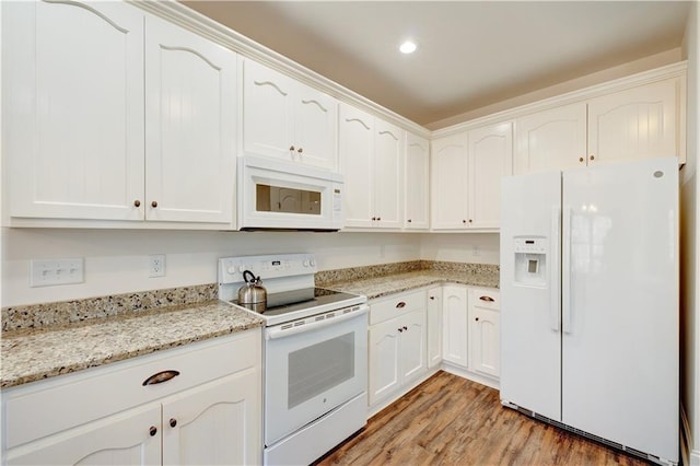 kitchen with light wood-style floors, white appliances, white cabinets, and light stone countertops