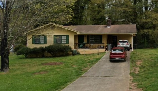 ranch-style home with a porch, a front yard, a chimney, and driveway