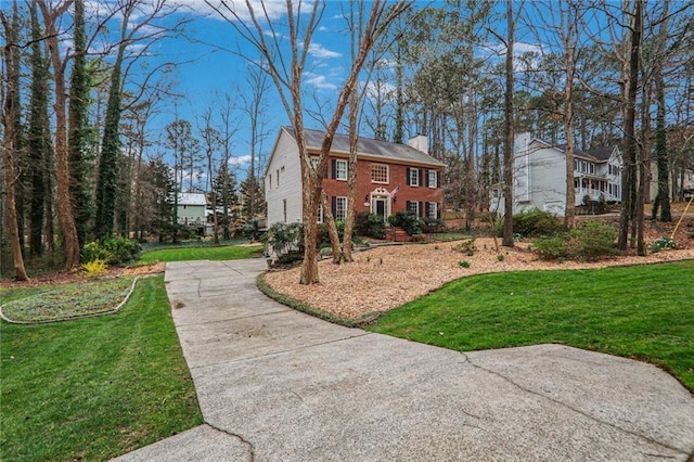 exterior space with a chimney and a lawn