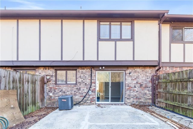 rear view of house with central AC unit and a patio area