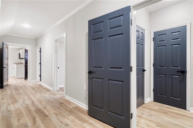 corridor featuring lofted ceiling, light hardwood / wood-style flooring, and ornamental molding