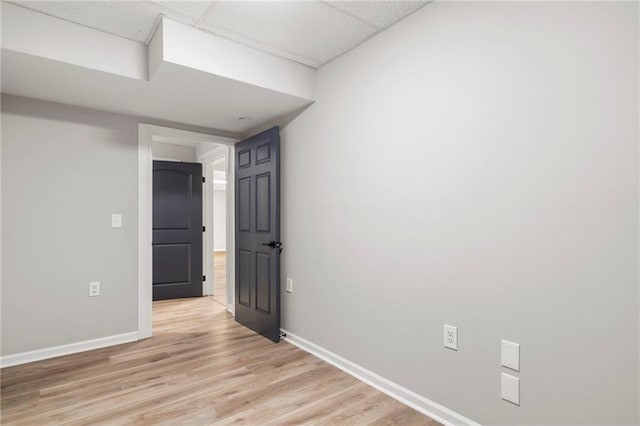 interior space with a paneled ceiling and light wood-type flooring