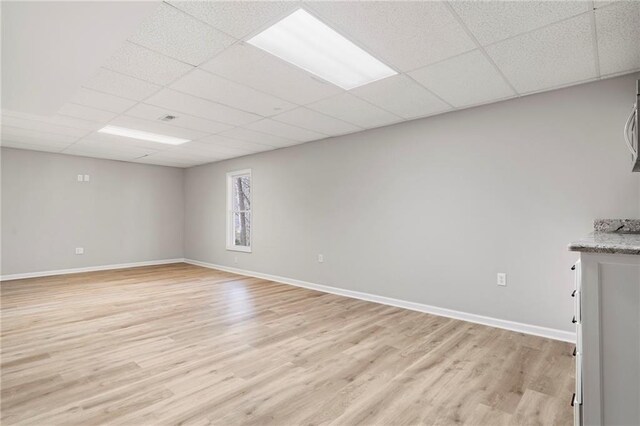 interior space with a paneled ceiling and light wood-type flooring