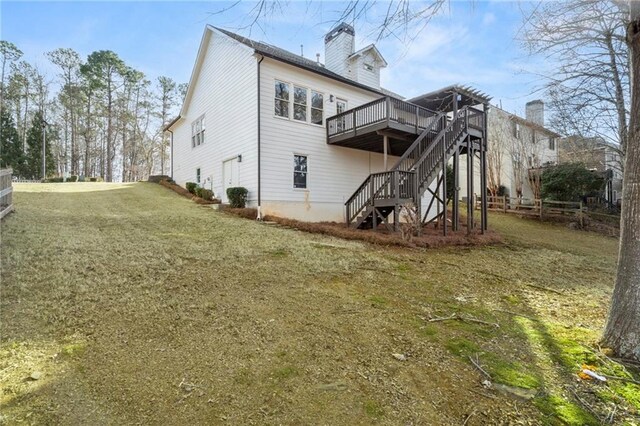 back of house featuring a wooden deck and a yard