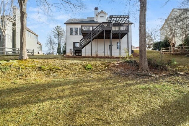 rear view of property featuring a yard and a deck