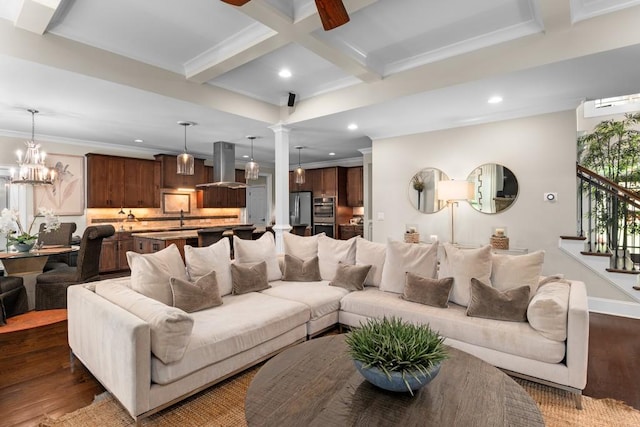 living room with dark wood-type flooring, beamed ceiling, sink, a chandelier, and crown molding