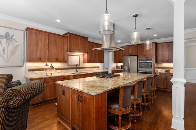 kitchen featuring hanging light fixtures, a large island, stainless steel appliances, and decorative columns