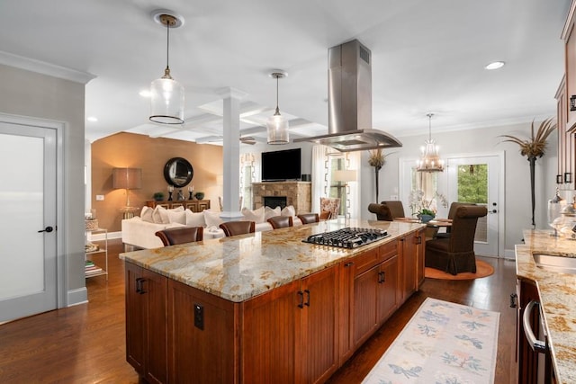 kitchen with stainless steel gas stovetop, dark wood-type flooring, island range hood, and decorative light fixtures