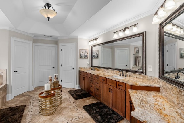 bathroom featuring crown molding, a raised ceiling, and vanity