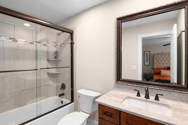 full bathroom featuring toilet, bath / shower combo with glass door, and vanity