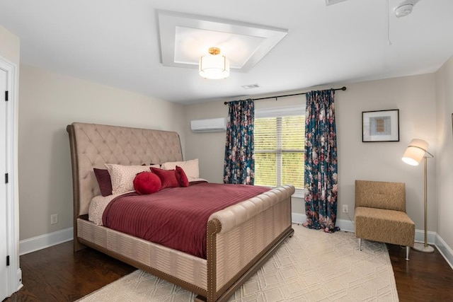 bedroom with a wall mounted AC and hardwood / wood-style flooring