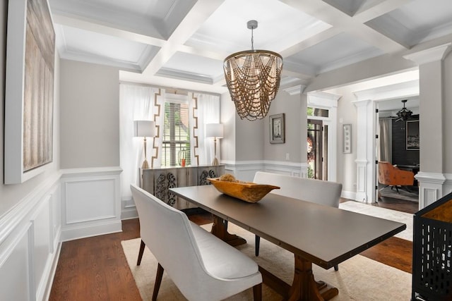 dining space featuring beamed ceiling, coffered ceiling, dark wood-type flooring, ornamental molding, and ceiling fan with notable chandelier