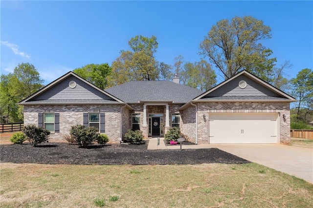 view of front of home featuring an attached garage, fence, brick siding, a front lawn, and driveway