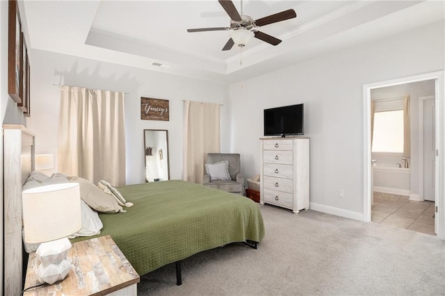 bedroom featuring ensuite bathroom, baseboards, a raised ceiling, and carpet
