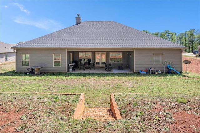 back of property with a patio, a chimney, and a yard