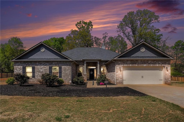 view of front of property featuring an attached garage, concrete driveway, a front yard, and fence