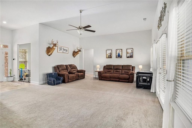 living room featuring carpet floors, ceiling fan, visible vents, and a healthy amount of sunlight
