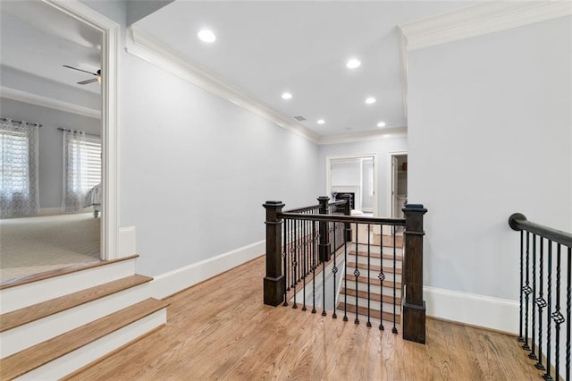 staircase featuring crown molding, wood finished floors, baseboards, ceiling fan, and recessed lighting