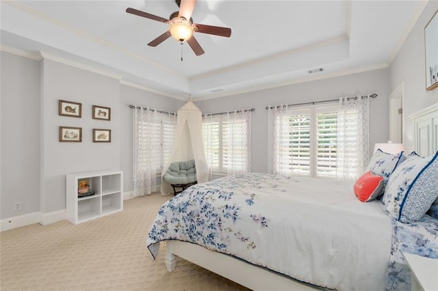 bedroom featuring carpet floors, a tray ceiling, crown molding, a ceiling fan, and baseboards