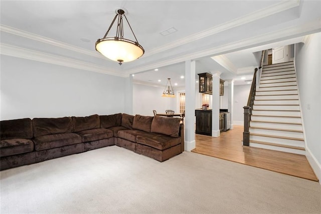 living room with light carpet, stairway, ornamental molding, a tray ceiling, and baseboards