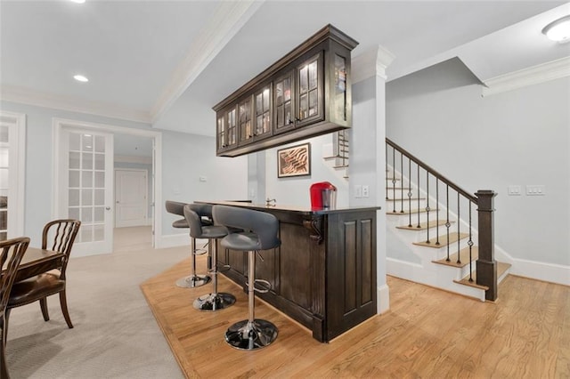 indoor wet bar with crown molding, stairs, baseboards, and recessed lighting
