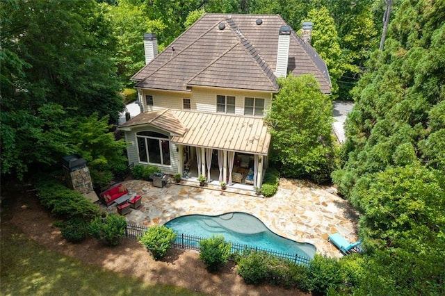 back of house with a chimney, a patio, and fence