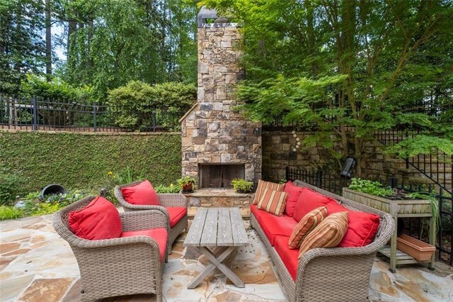 view of patio featuring fence and an outdoor living space with a fireplace