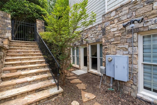 view of side of property with stone siding and stairs