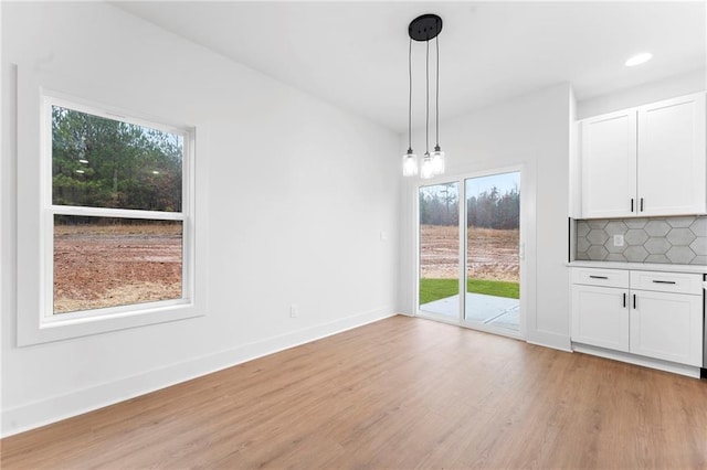 kitchen with sink, white cabinetry, hanging light fixtures, appliances with stainless steel finishes, and a kitchen island