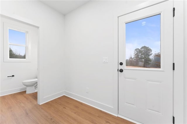 interior space with electric dryer hookup, hookup for a washing machine, water heater, and hardwood / wood-style flooring