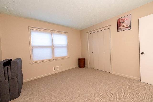 carpeted bedroom with a closet and a textured ceiling